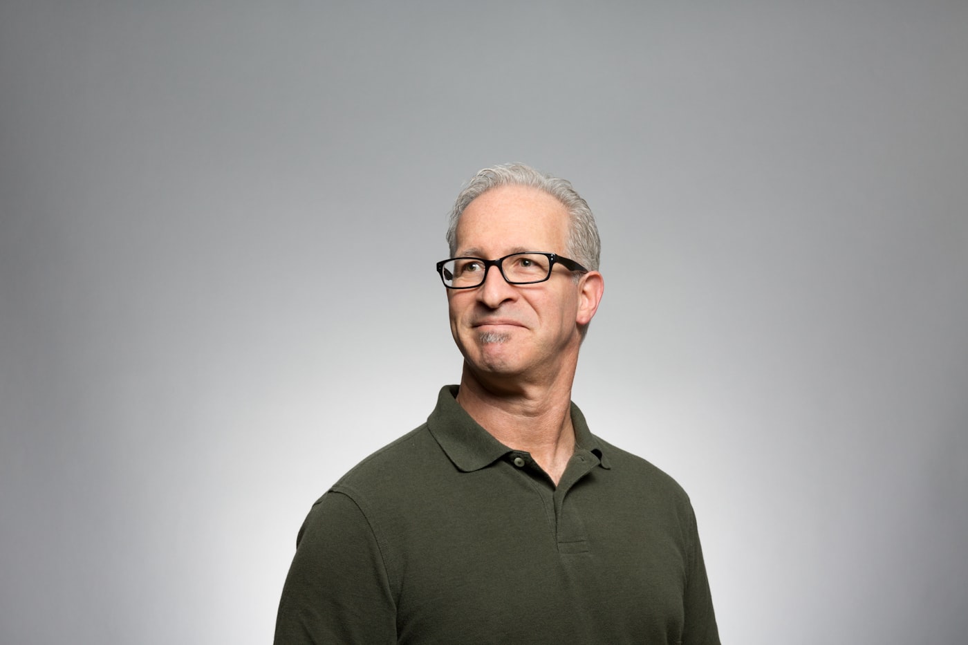 An advisor in a navy shirt standing with arms crossed