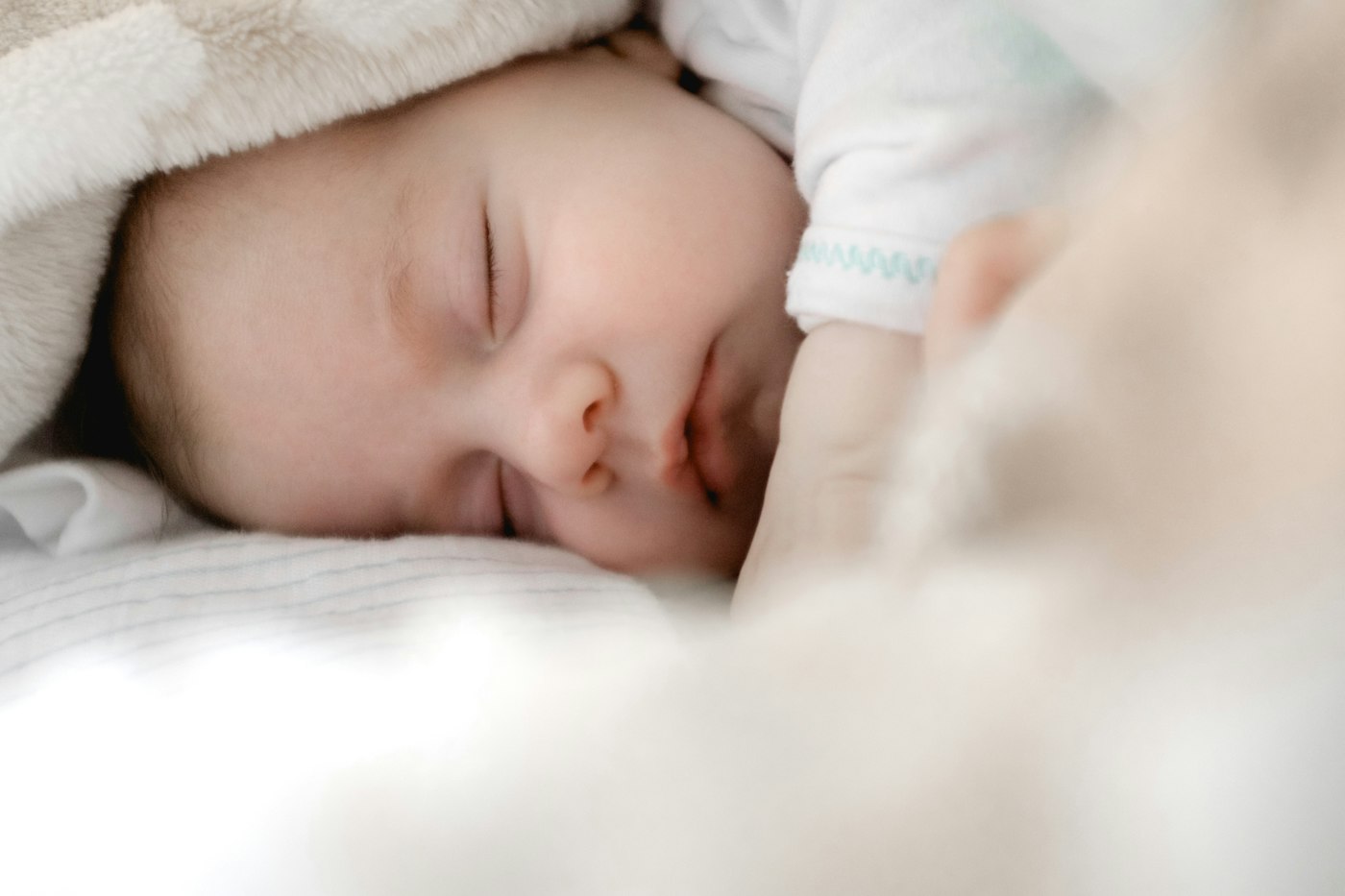 A parent holding a sleeping baby